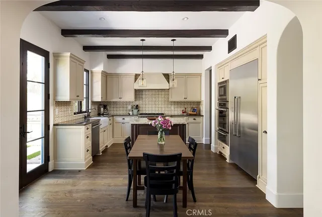 a kitchen with a refrigerator a table and chairs in it
