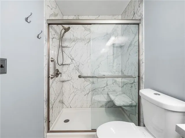 a bathroom with a toilet and a shower