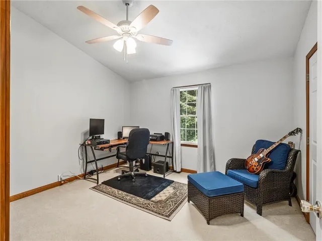 a view of a workspace with furniture and a window