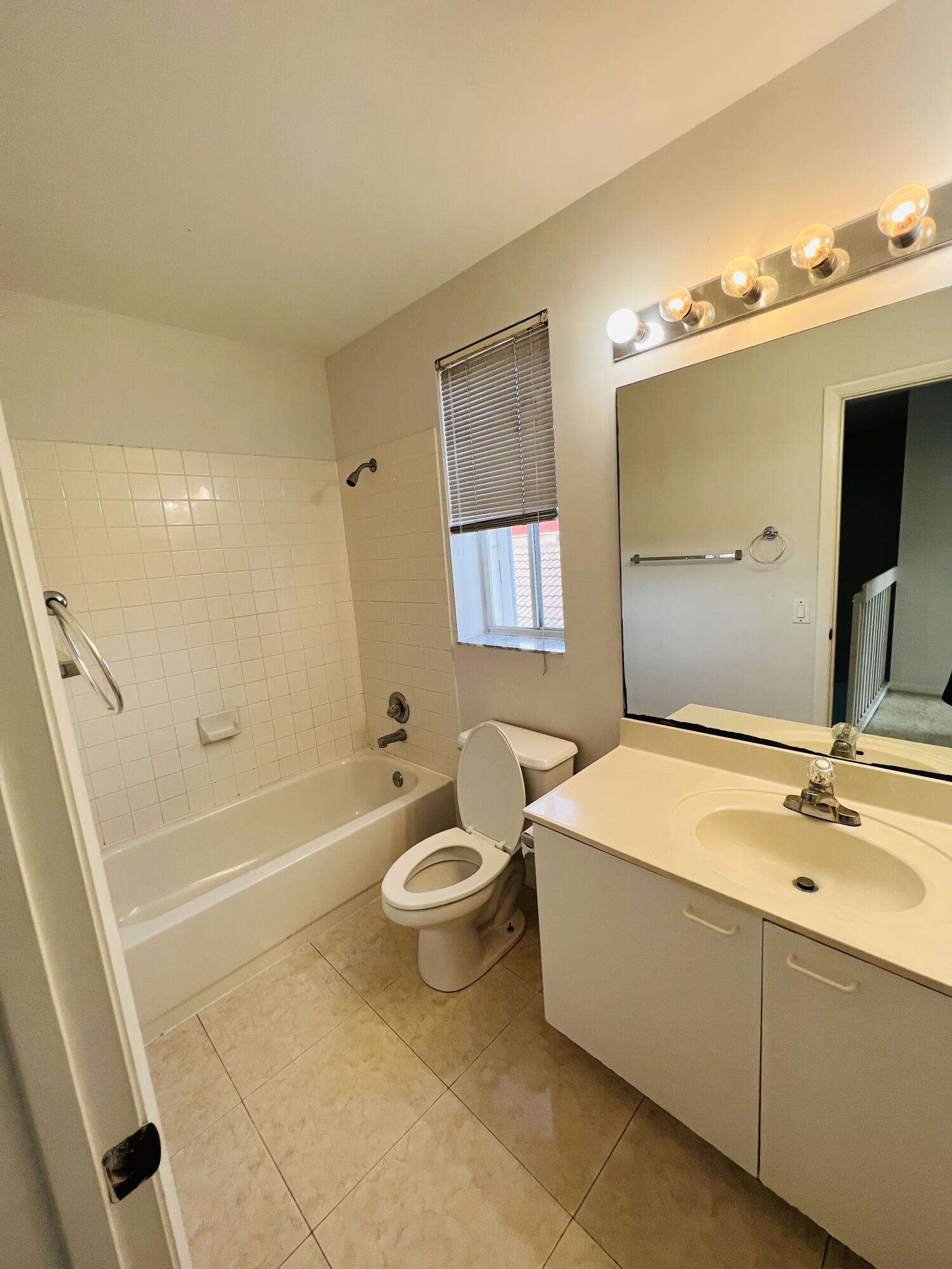 439 Talavera Road Weston, FL 33326 - Photo 13 of 17 a bathroom with a sink a toilet a mirror and bathtub