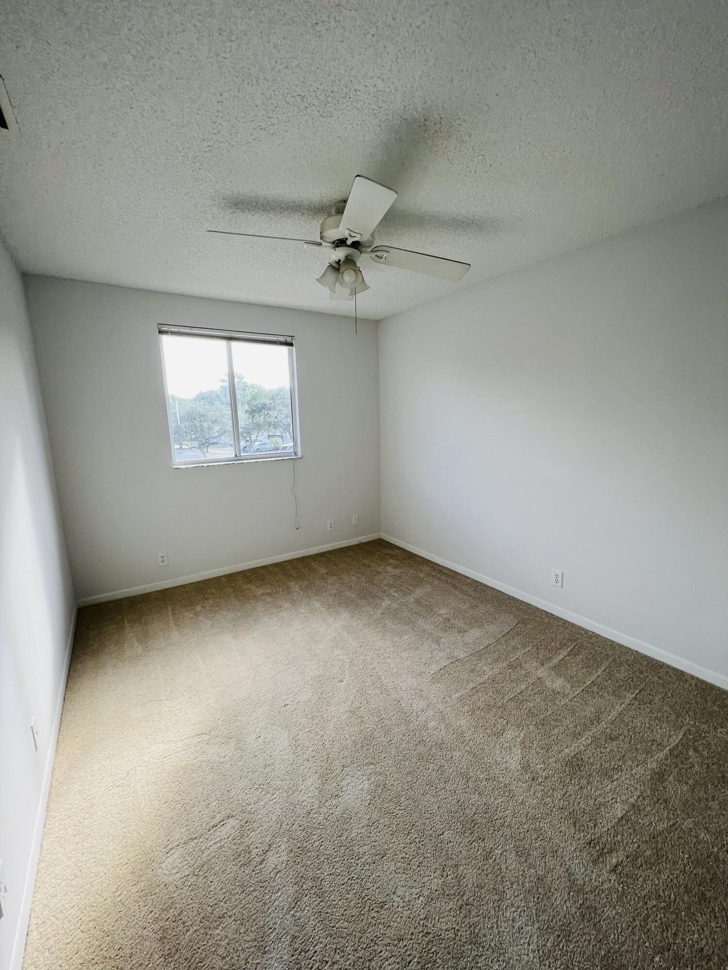 439 Talavera Road Weston, FL 33326 - Photo 7 of 17 an empty room with windows and ceiling fan