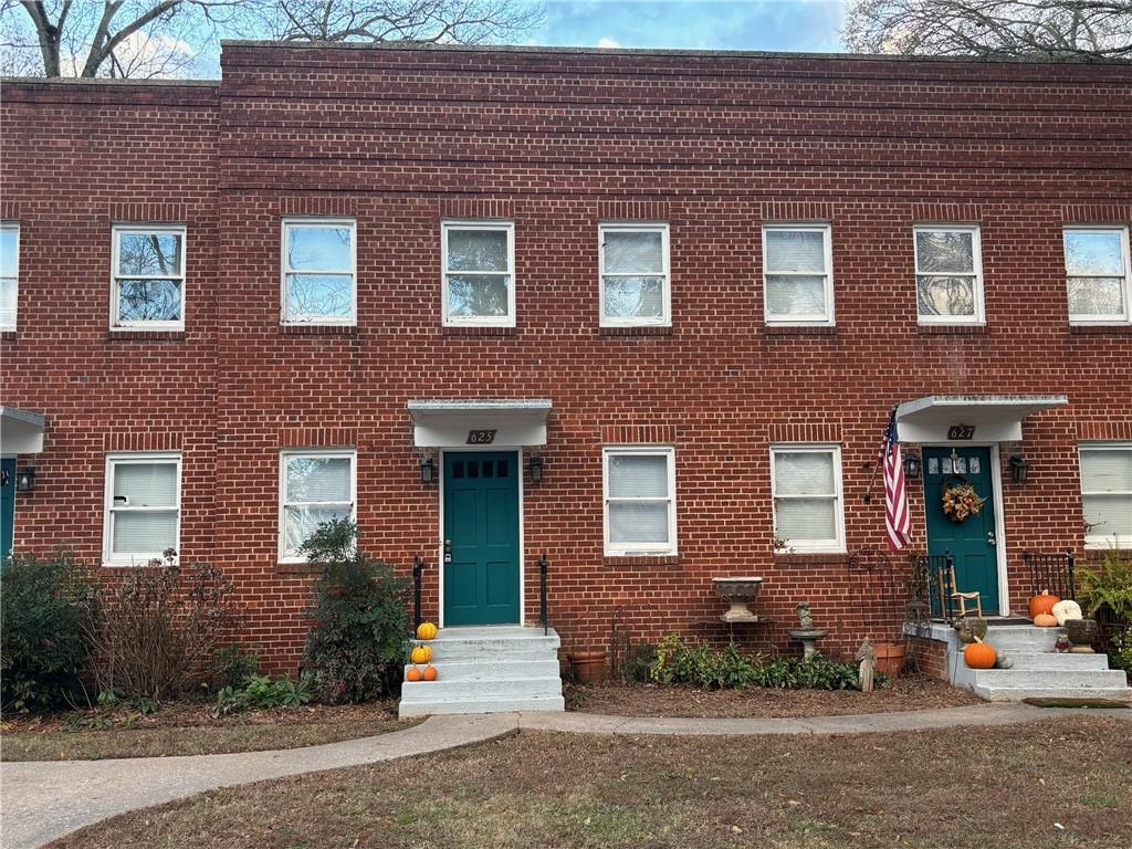 a front view of a house with yard and green space