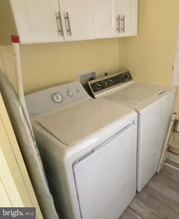a view of a house with a small yard and large trees