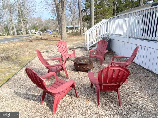 a view of backyard with wooden fence and large trees