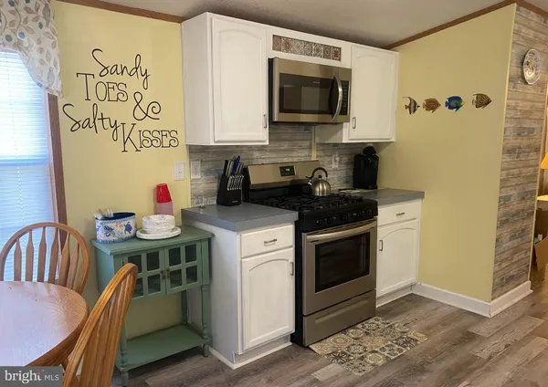 a kitchen with stainless steel appliances a stove a microwave a sink and cabinets