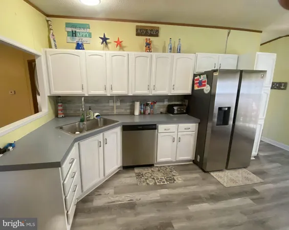 a kitchen with a sink a refrigerator and cabinets