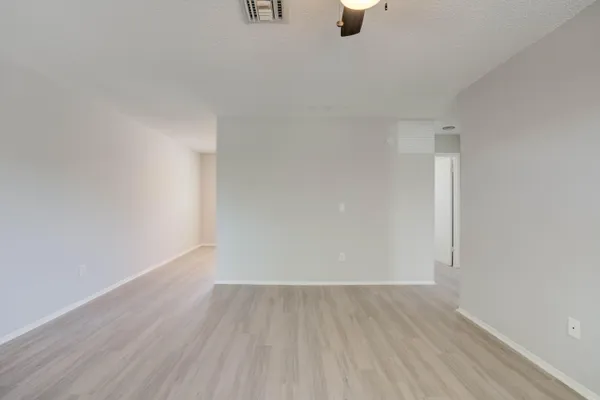 a view of an empty room with wooden floor