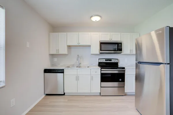 a kitchen with stainless steel appliances a stove a microwave and a refrigerator