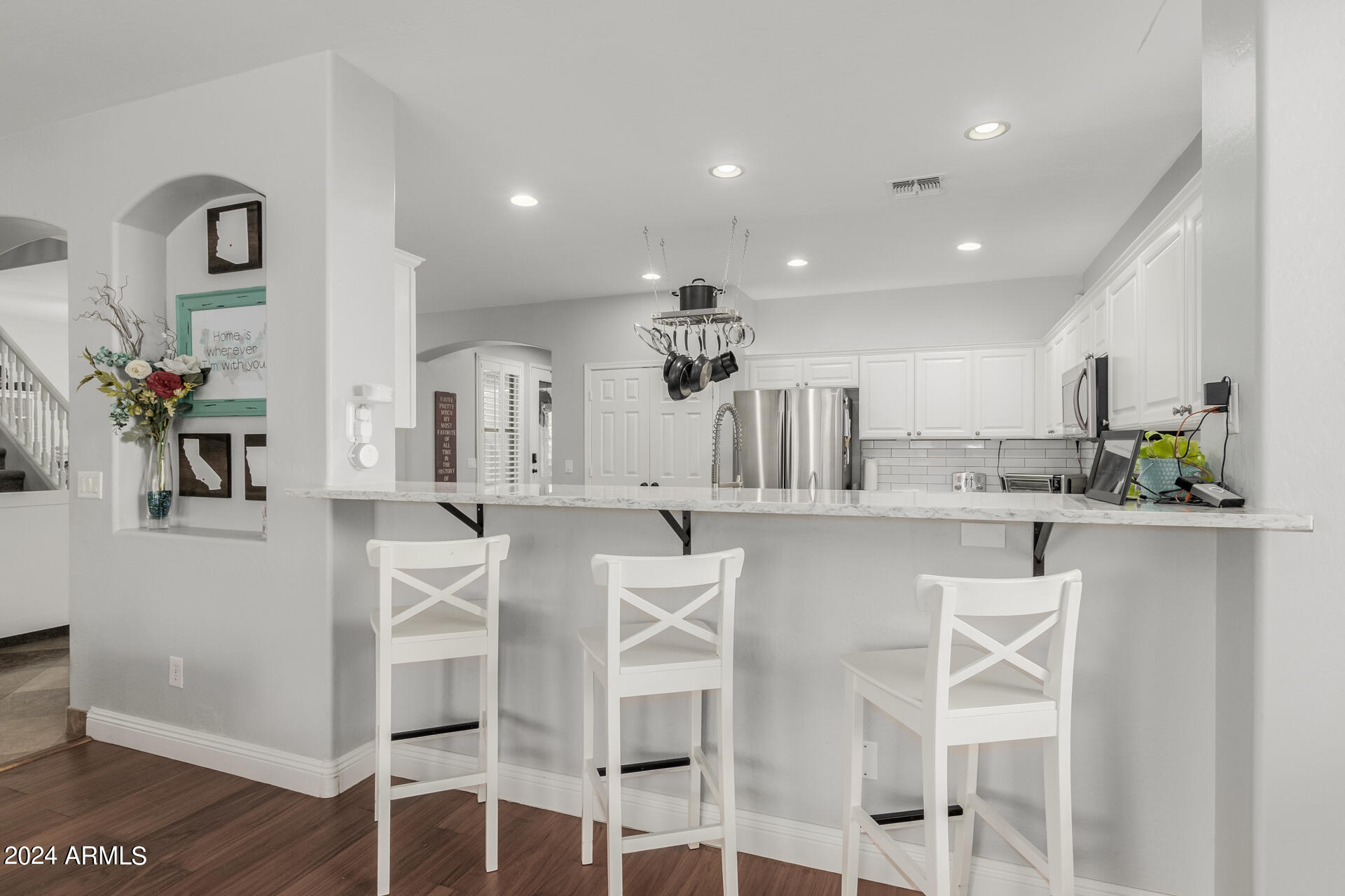 3353 East Blue Ridge Way Gilbert, AZ 85298 - Photo 11 of 50 a kitchen with white cabinets and chairs