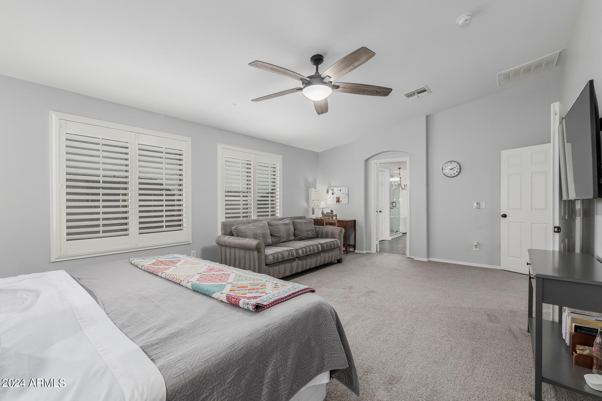 3353 East Blue Ridge Way Gilbert, AZ 85298 - Photo 18 of 50 a spacious bedroom with a bed a couch and a large window