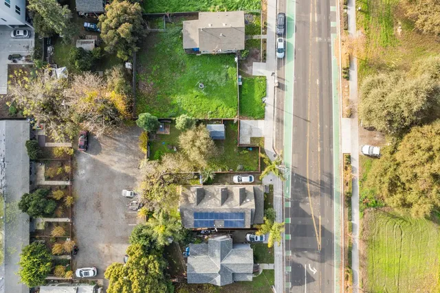 an aerial view of a house with a yard and large trees