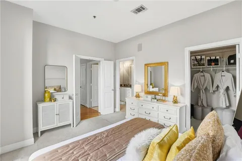 a spacious bedroom with a bed and a view of living room