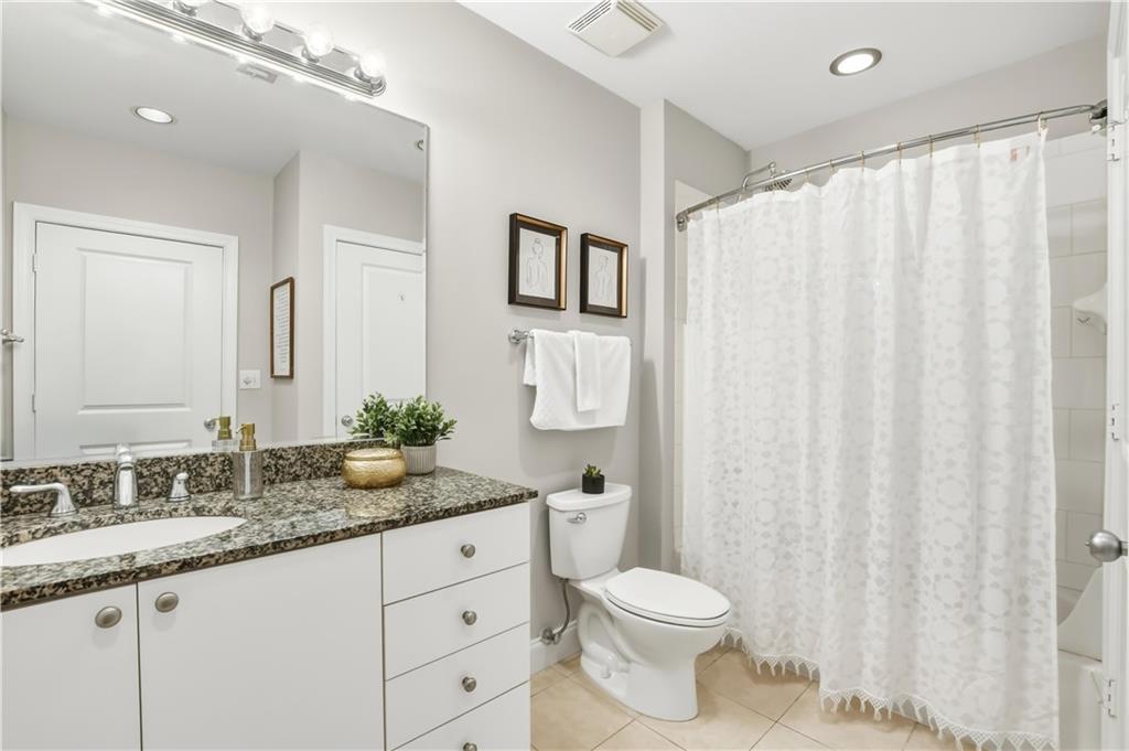 2626 Peachtree Road Northwest, Unit 606 Atlanta, GA 30305 - Photo 15 of 27 a bathroom with a granite countertop sink and a mirror