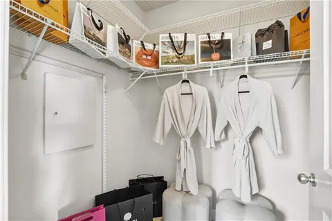 a view of walk in closet with clothes and shoes