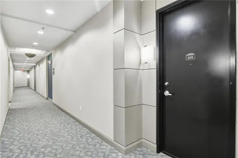 a view of hallway with stainless steel appliances granite countertop cabinets and a glass door
