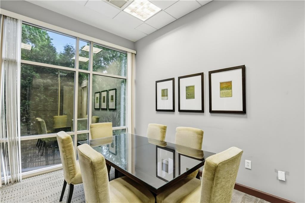 2626 Peachtree Road Northwest, Unit 606 Atlanta, GA 30305 - Photo 24 of 27 a view of a dining room with furniture large windows and wooden floor