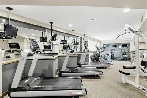 a room with gym equipment and a view of living room