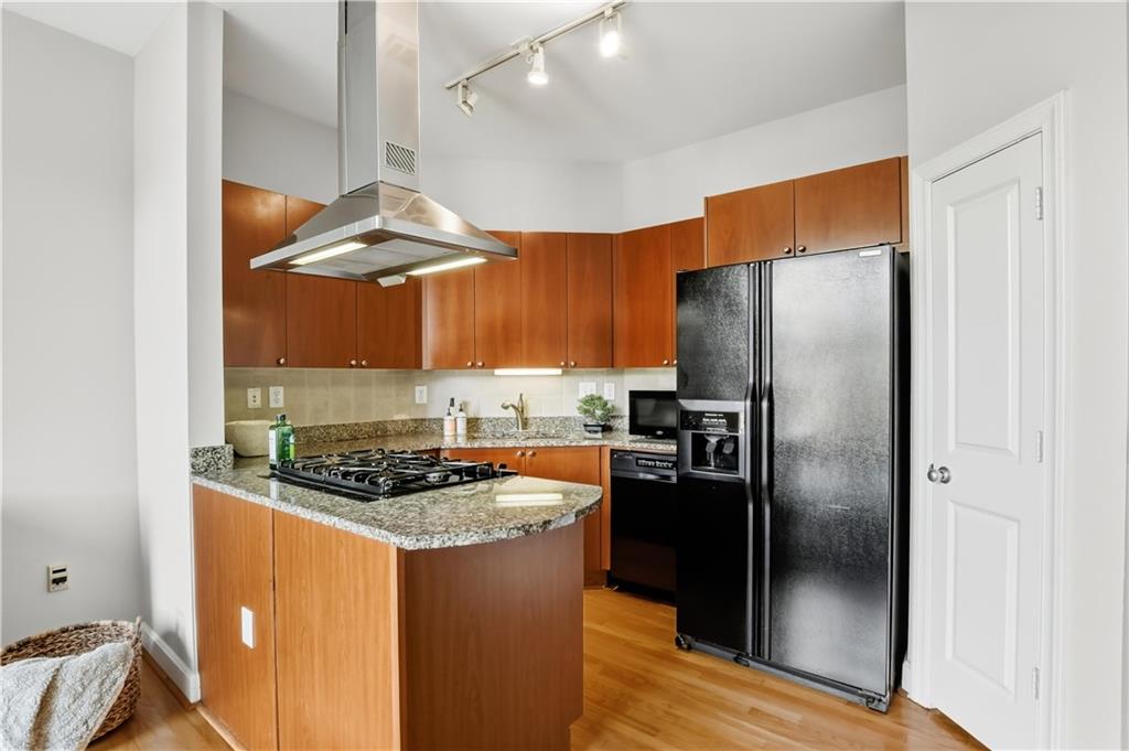 2626 Peachtree Road Northwest, Unit 606 Atlanta, GA 30305 - Photo 7 of 27 a kitchen with stainless steel appliances granite countertop a refrigerator a stove and a sink