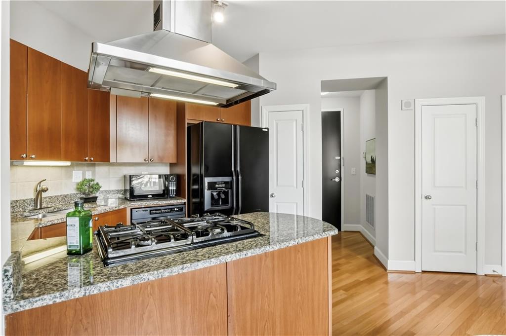 2626 Peachtree Road Northwest, Unit 606 Atlanta, GA 30305 - Photo 9 of 27 a kitchen with stainless steel appliances granite countertop a stove refrigerator and cabinets