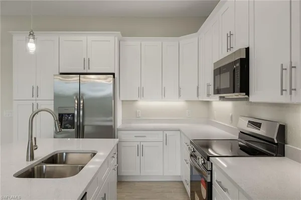 a kitchen with a sink microwave and cabinets
