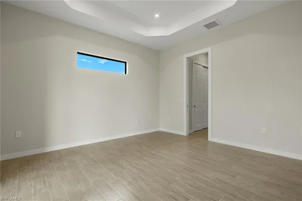 a view of an empty room with wooden floor