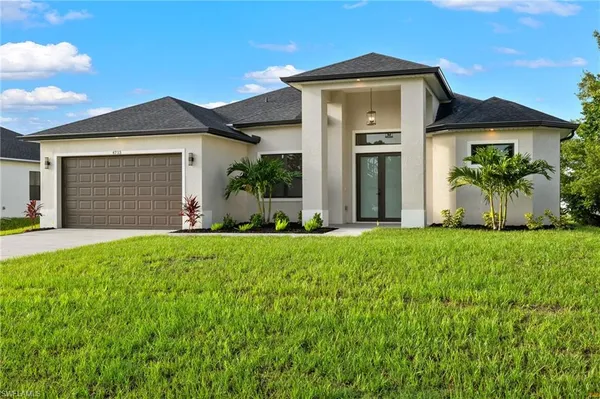a front view of a house with a yard and garage