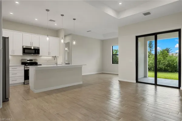 a large kitchen with stainless steel appliances a large counter top and a wooden floors