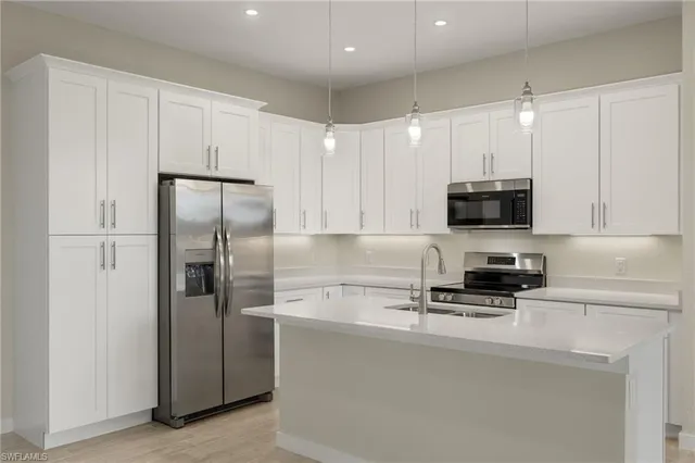 a kitchen with stainless steel appliances a refrigerator a stove a microwave and cabinets