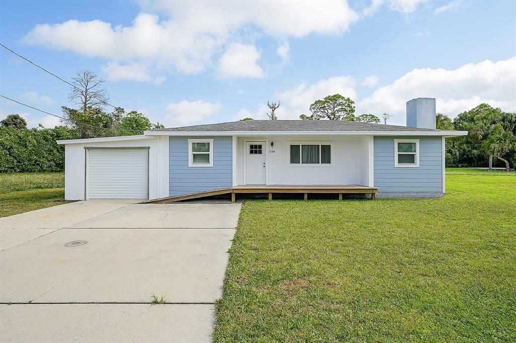 8164 Archie Street Englewood, FL 34224 - Photo 1 of 42 a front view of a house with garden