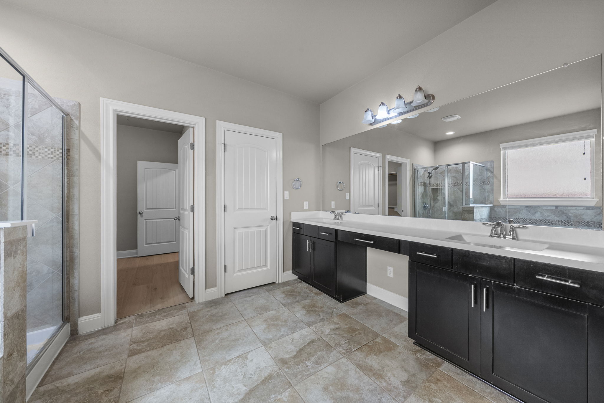 4401 Trinity Woods Street Leander, TX 78641 - Photo 19 of 37 A spacious primary bathroom with a double vanity and a glass-enclosed shower.