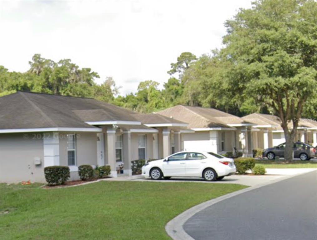 11322 Southeast 55th Avenue Road, Unit 1301 Belleview, FL 34420 - Photo 1 of 1 a white house covered with tall trees