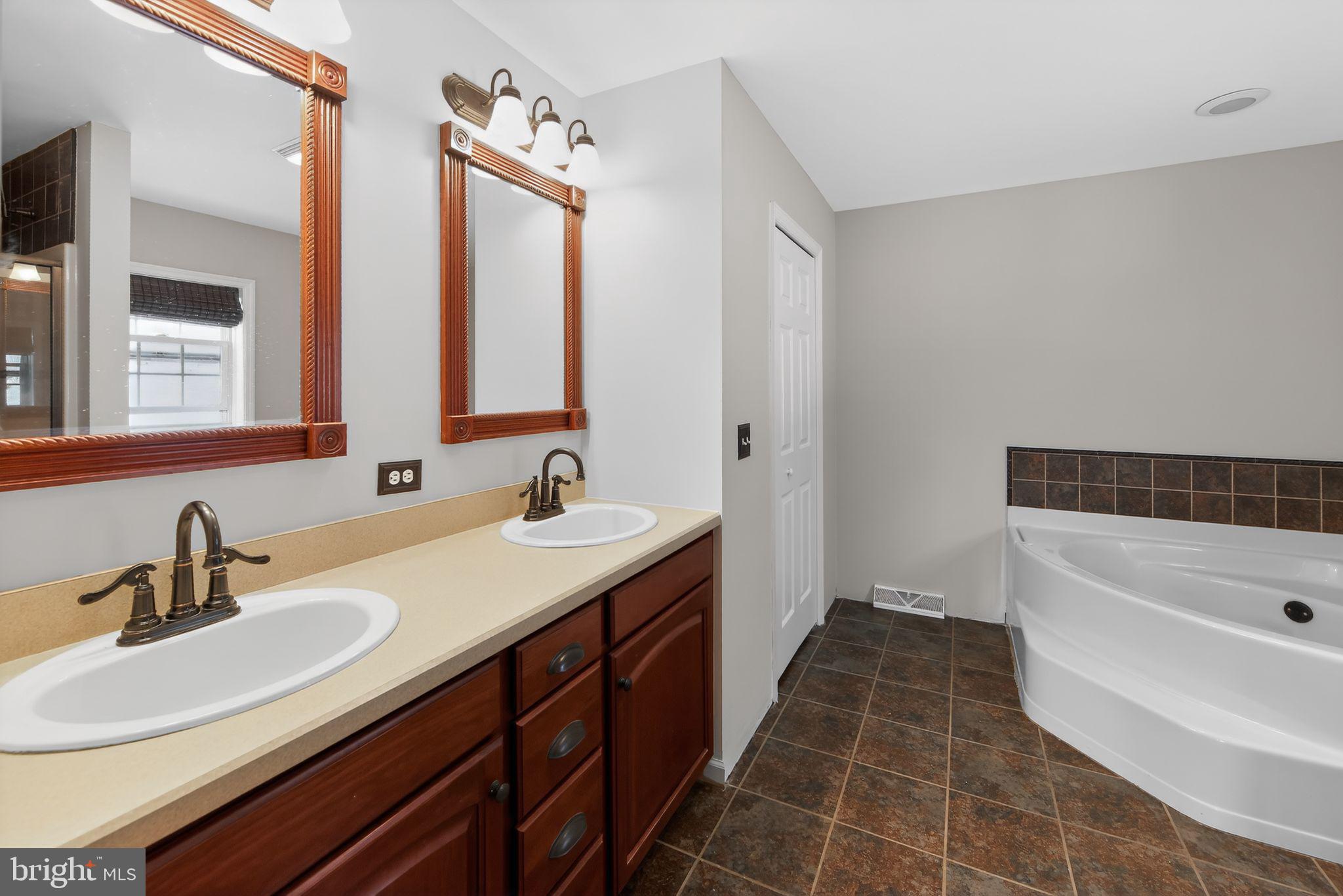 3211 Coventryville Road Pottstown, PA 19465 - Photo 24 of 37 a bathroom with a double vanity sink a mirror and a bathtub