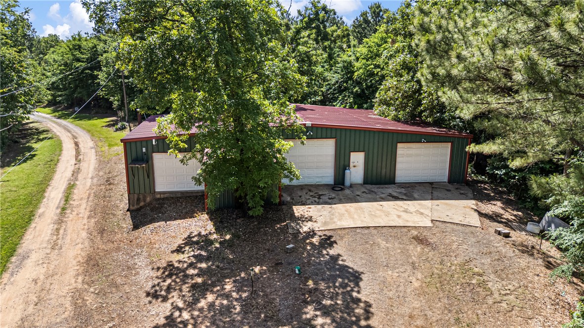 655 Charton Road Morrilton, AR 72110 - Photo 46 of 49 Metal outbuilding featuring a deep green exterior, red roof, and two roll-up garage doors