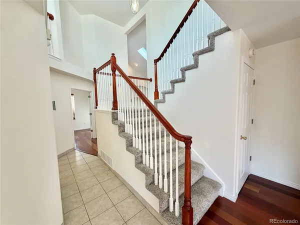 a view of staircase with lots of frames on wall and wooden floor
