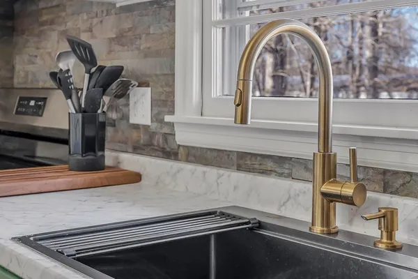 a kitchen with stainless steel appliances a stove a refrigerator and a fireplace