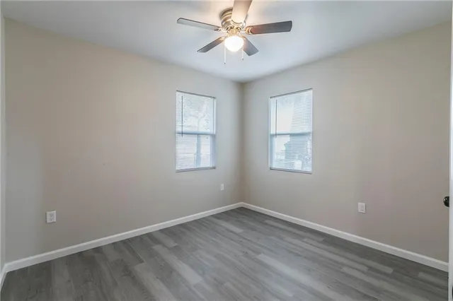 an empty room with a window and a fan