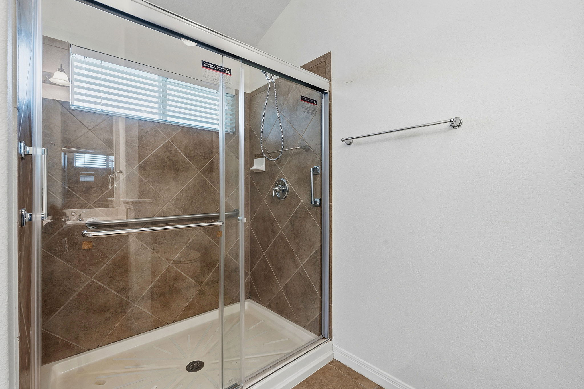 8541 Inca Dove Drive Austin, TX 78729 - Photo 17 of 28 The primary ensuite comes with a spacious walk-in shower with tasteful tile backsplash.