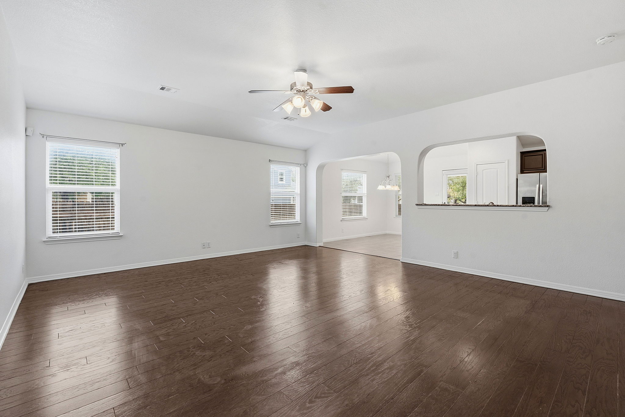 8541 Inca Dove Drive Austin, TX 78729 - Photo 2 of 28 Inside, the sun-filled living area offers plenty of room to relax and gather, featuring tall ceilings, rich wood flooring, and crisp neutral finishes that create a bright, inviting feel.