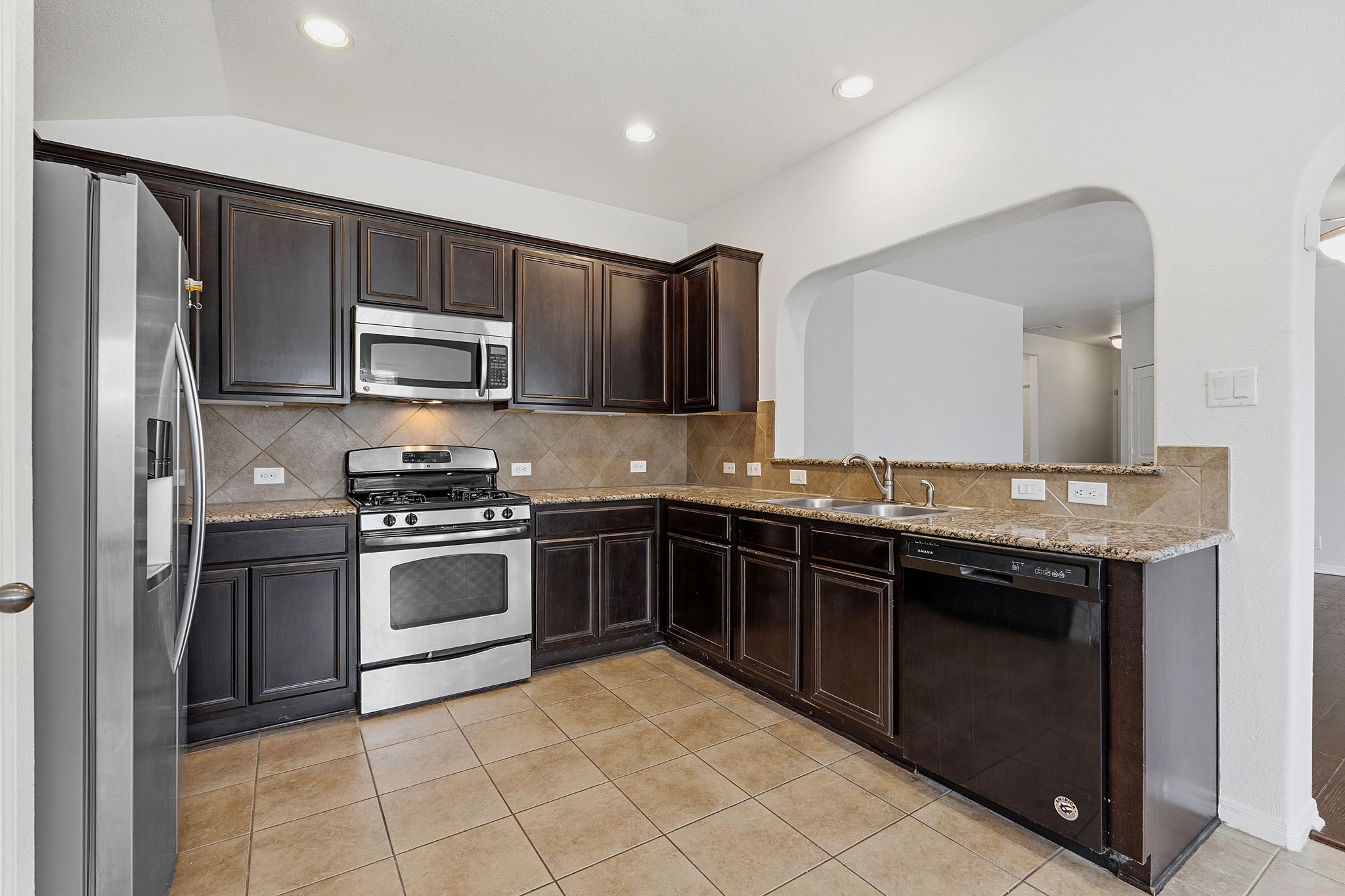 8541 Inca Dove Drive Austin, TX 78729 - Photo 10 of 28 Appliances include a stainless steel gas range and microwave plus a dishwasher.