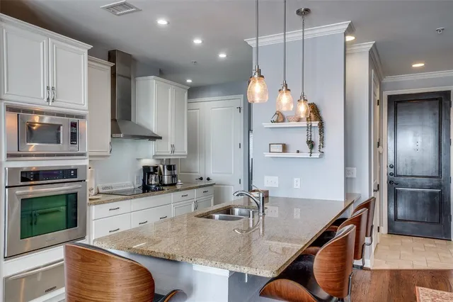 a kitchen with stainless steel appliances granite countertop a sink a stove and a refrigerator