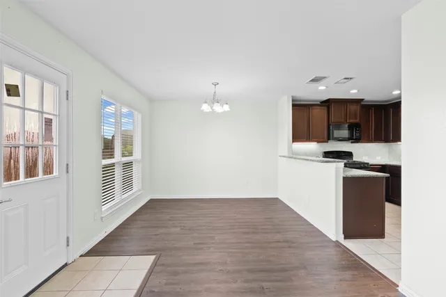 a view of kitchen with granite countertop cabinets and refrigerator