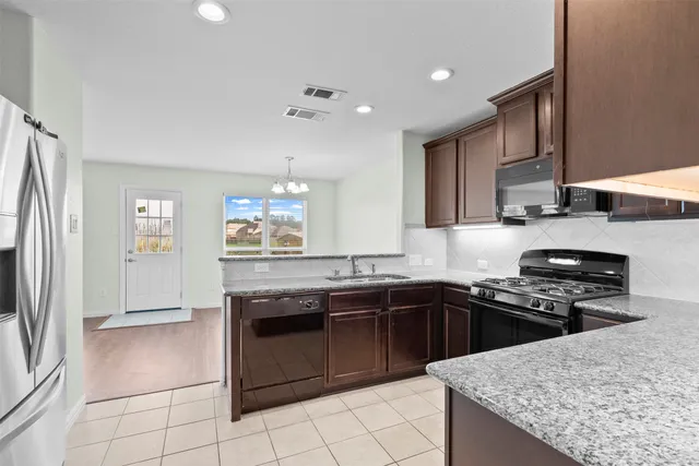 a kitchen with stainless steel appliances granite countertop a sink stove and refrigerator