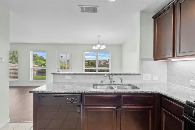 a kitchen with granite countertop a sink and a window