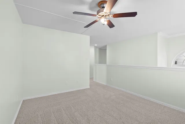 an empty room with a ceiling fan and a fan