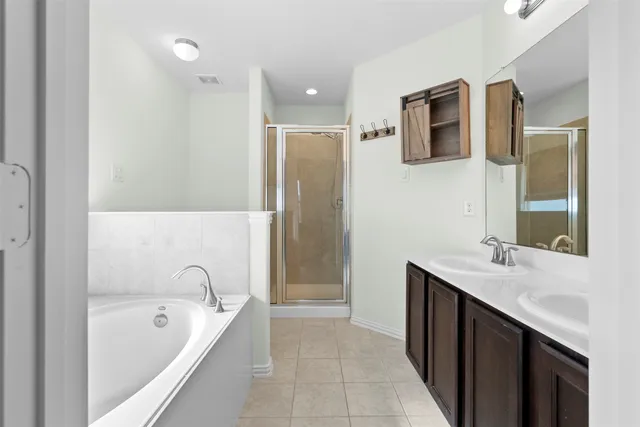 a bathroom with a tub a sink and mirror