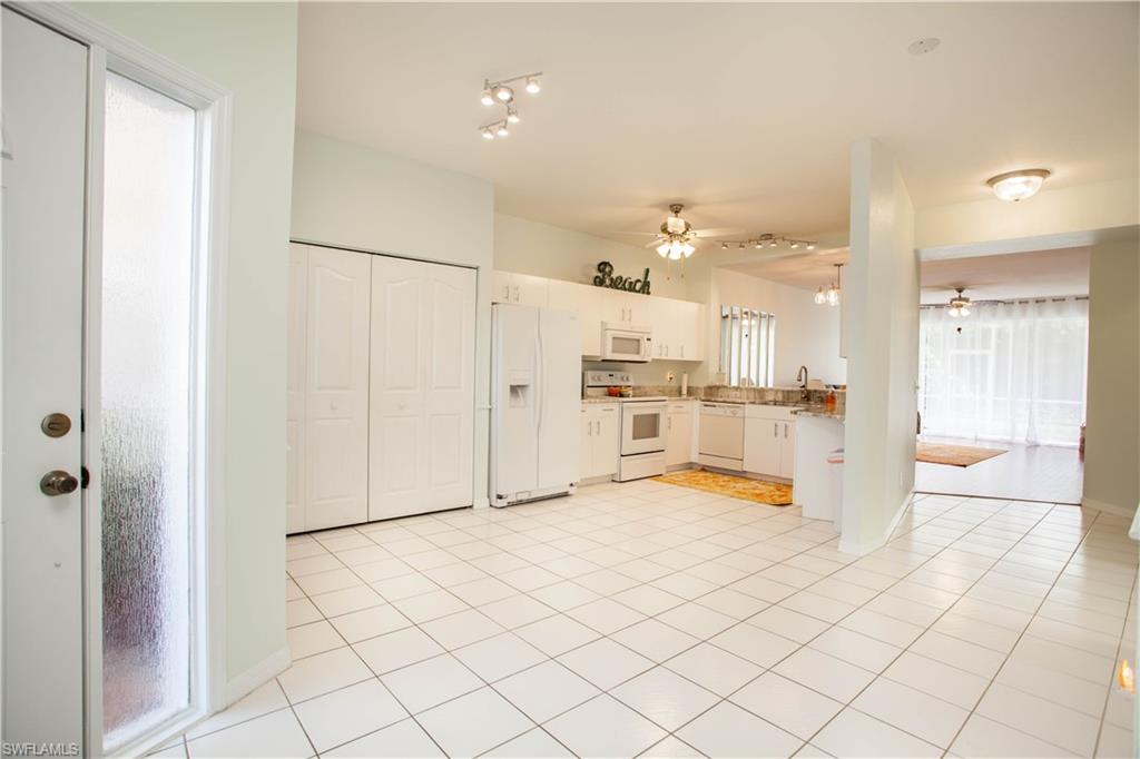 a large white kitchen with a sink and cabinets