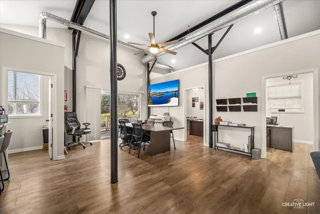 a living room with furniture a dining table wooden floor and a fireplace