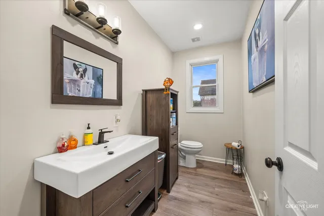 a bathroom with a sink mirror and toilet