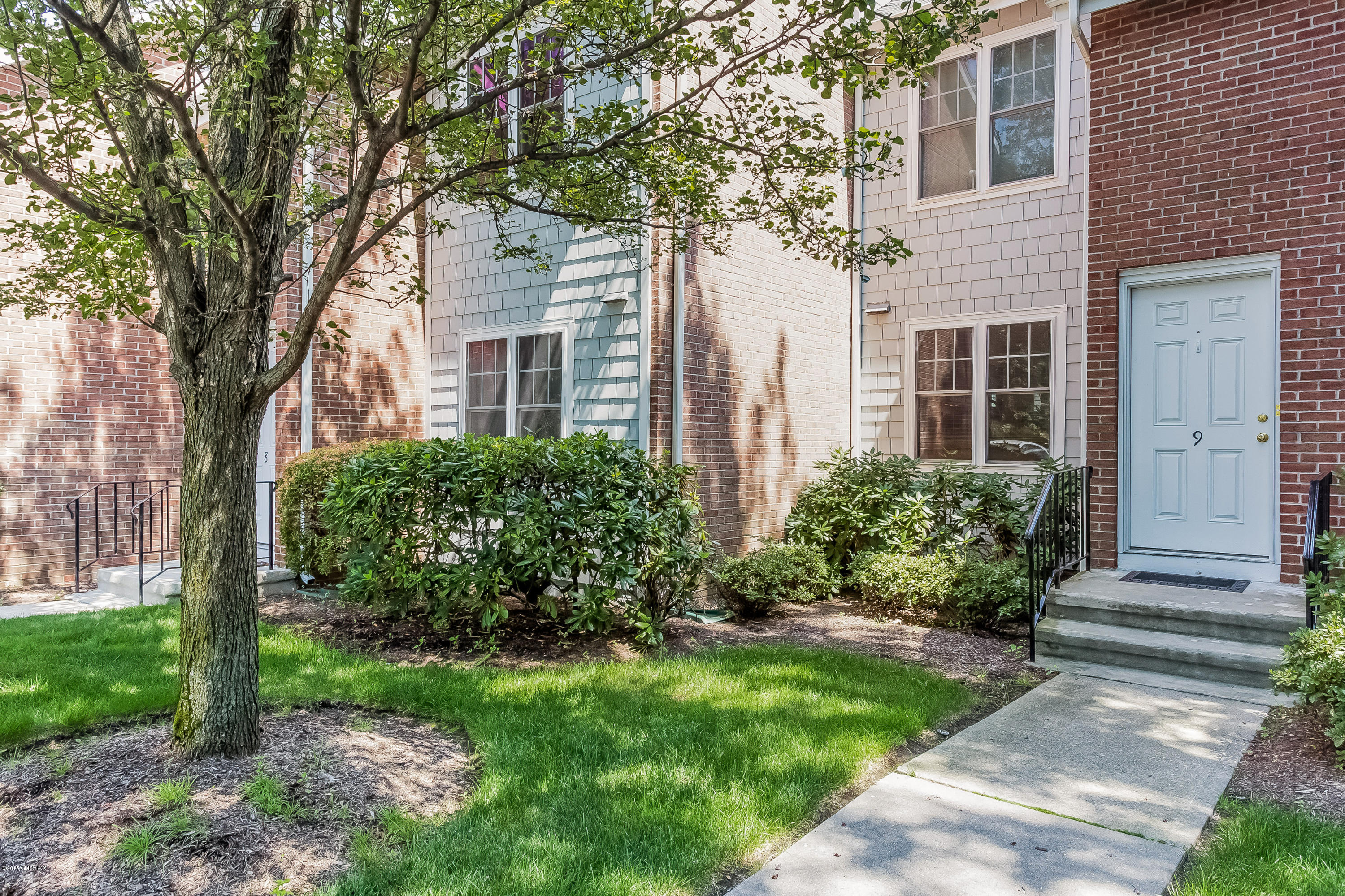 100 Strickland Road, Unit 9 Cos Cob, CT 06807 - Photo 2 of 21 a front view of a house with a garden