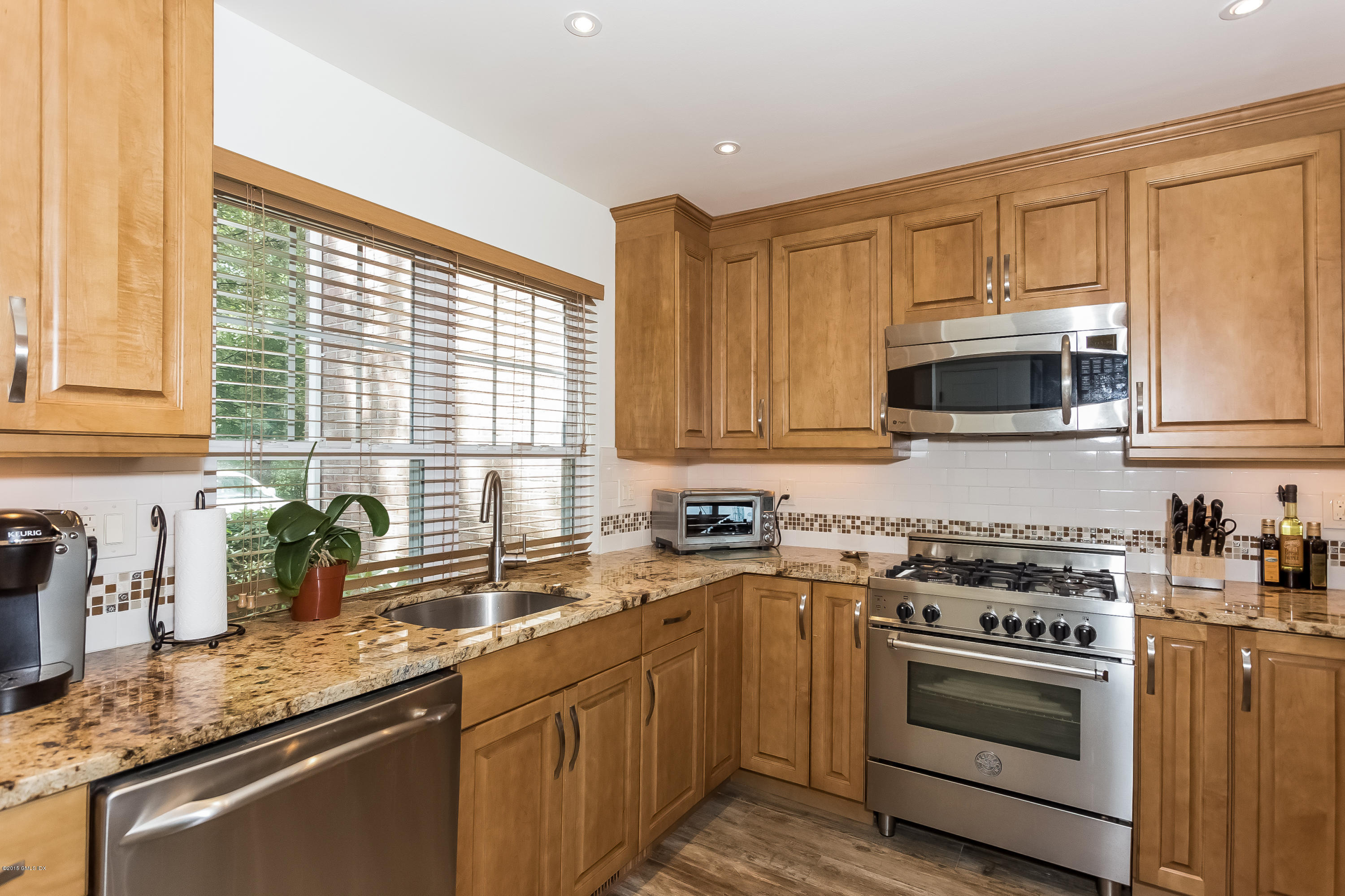 100 Strickland Road, Unit 9 Cos Cob, CT 06807 - Photo 6 of 21 a kitchen with stainless steel appliances a stove sink microwave and cabinets